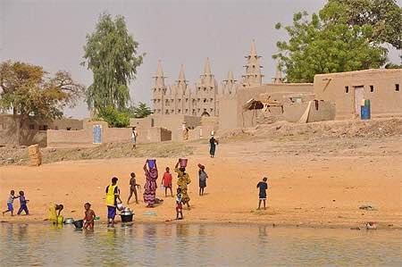 Au bord de l'eau, devant une mosquée en terre